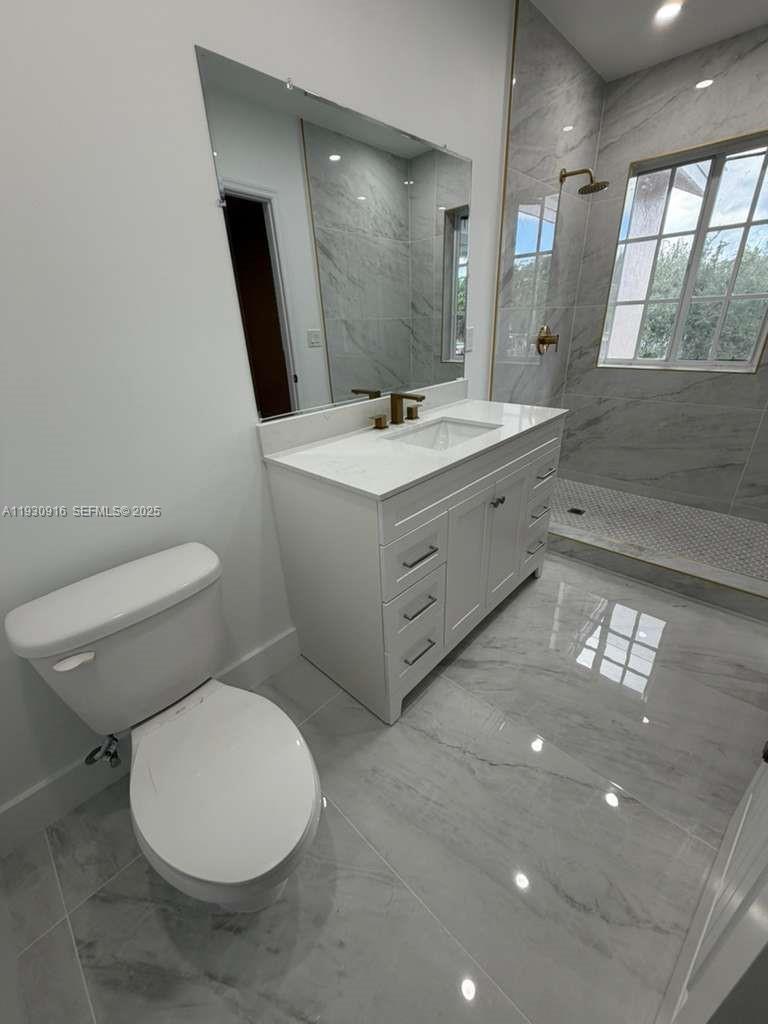 13982 Southwest 276th Street Homestead, FL 33032 - Photo 3 of 15 a bathroom with a toilet sink and mirror