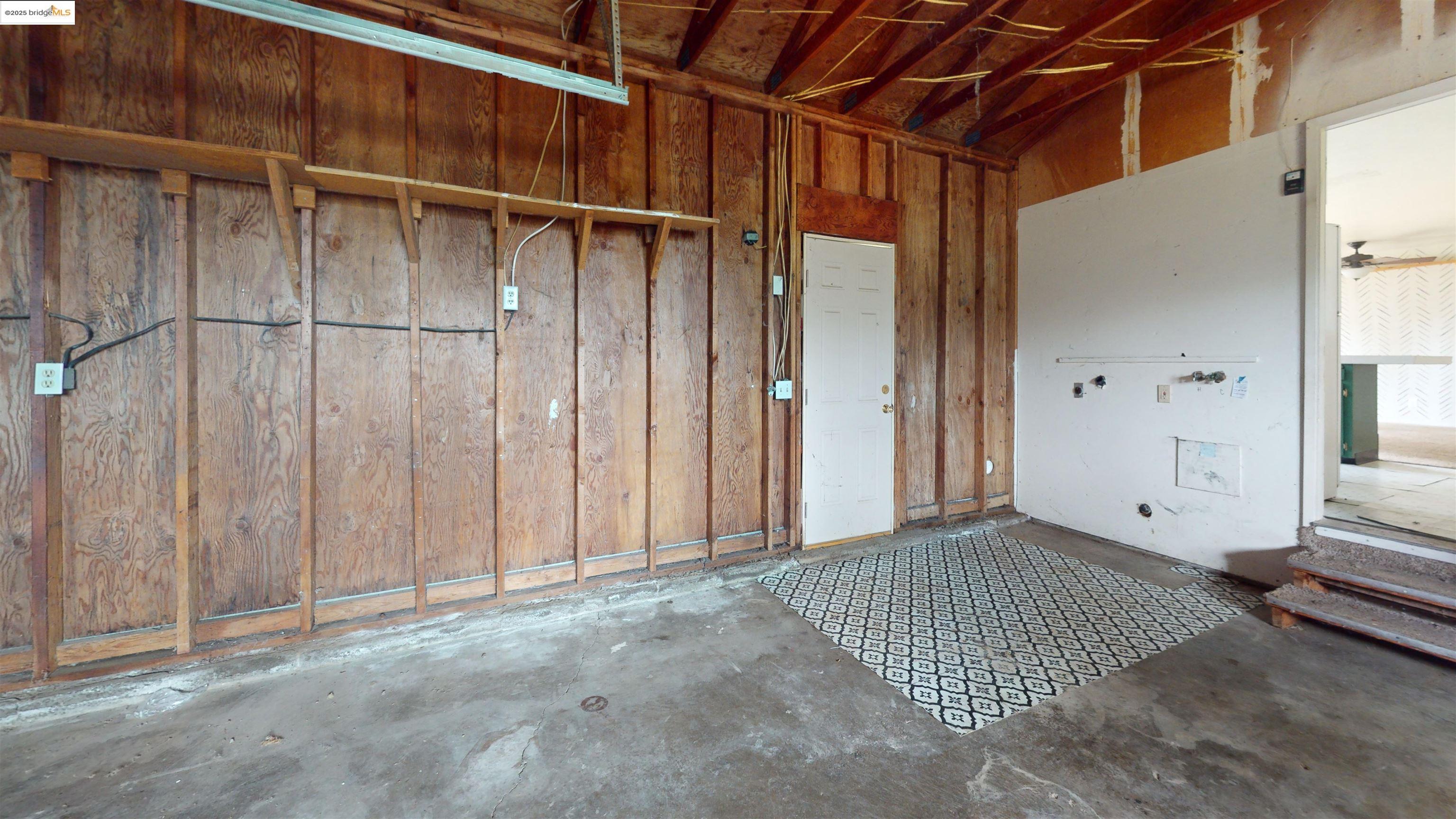 19817 Via Redonda Road Sonora, CA 95370 - Photo 16 of 23 Misc room with wood walls, concrete floors, and a garage