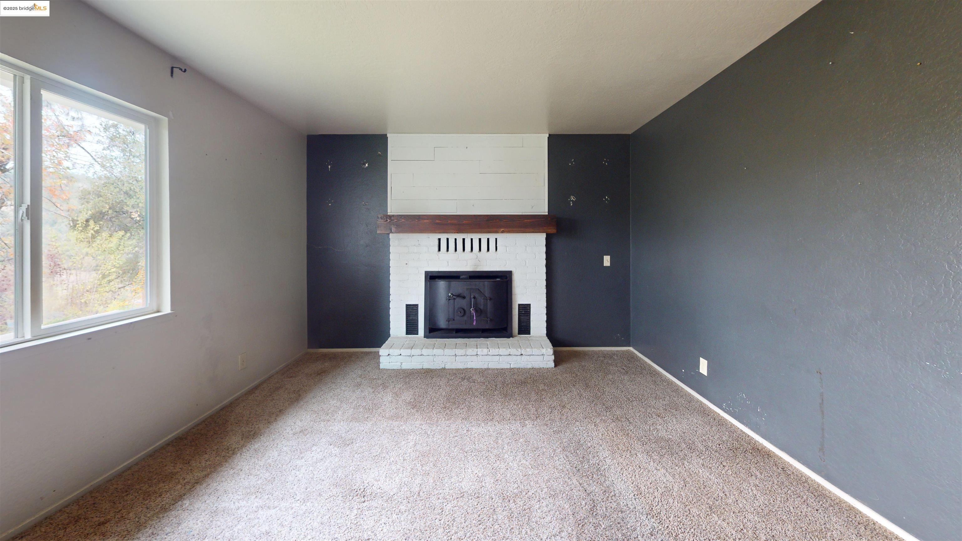 19817 Via Redonda Road Sonora, CA 95370 - Photo 3 of 23 Unfurnished living room featuring a fireplace and carpet