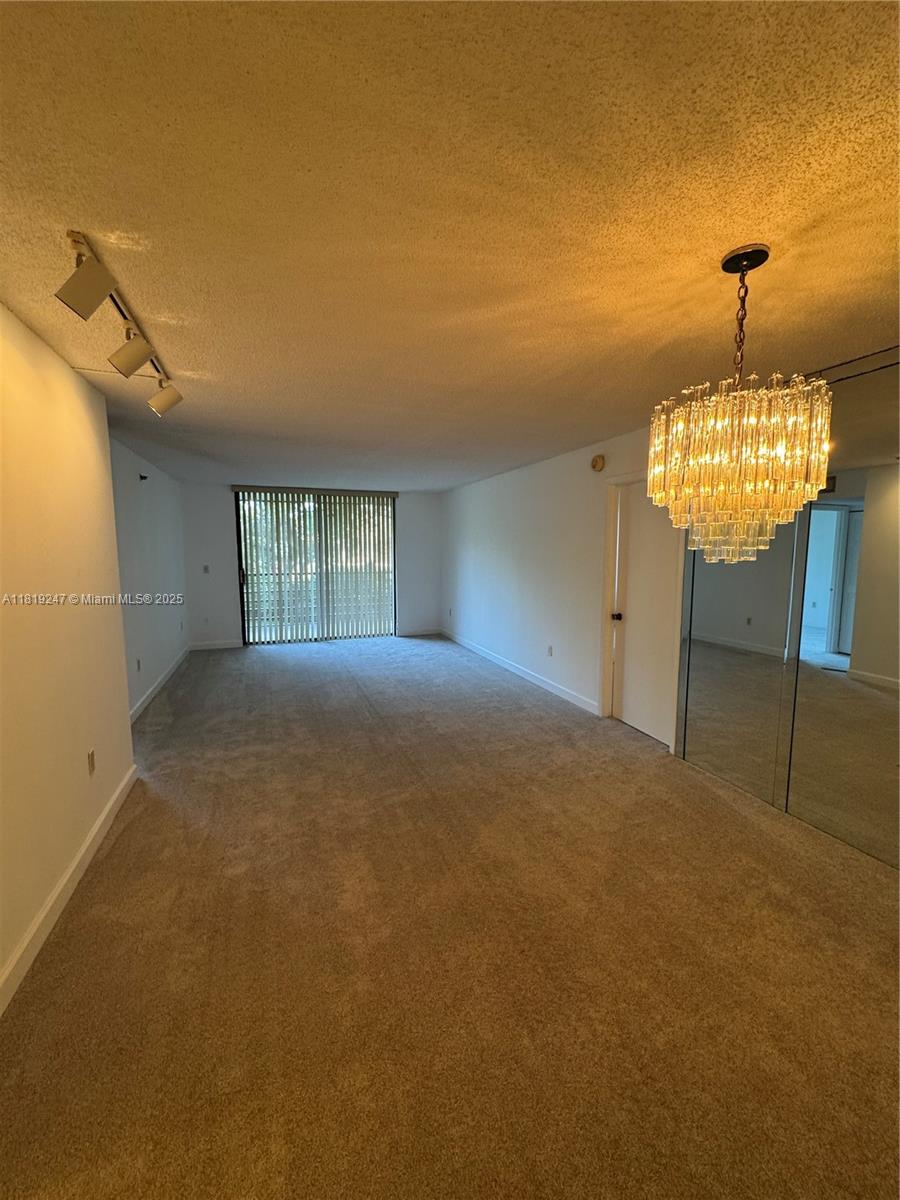 1100 St Charles Place, Unit 203 Pembroke Pines, FL 33026 - Photo 30 of 48 a view of an empty room with a chandelier fan