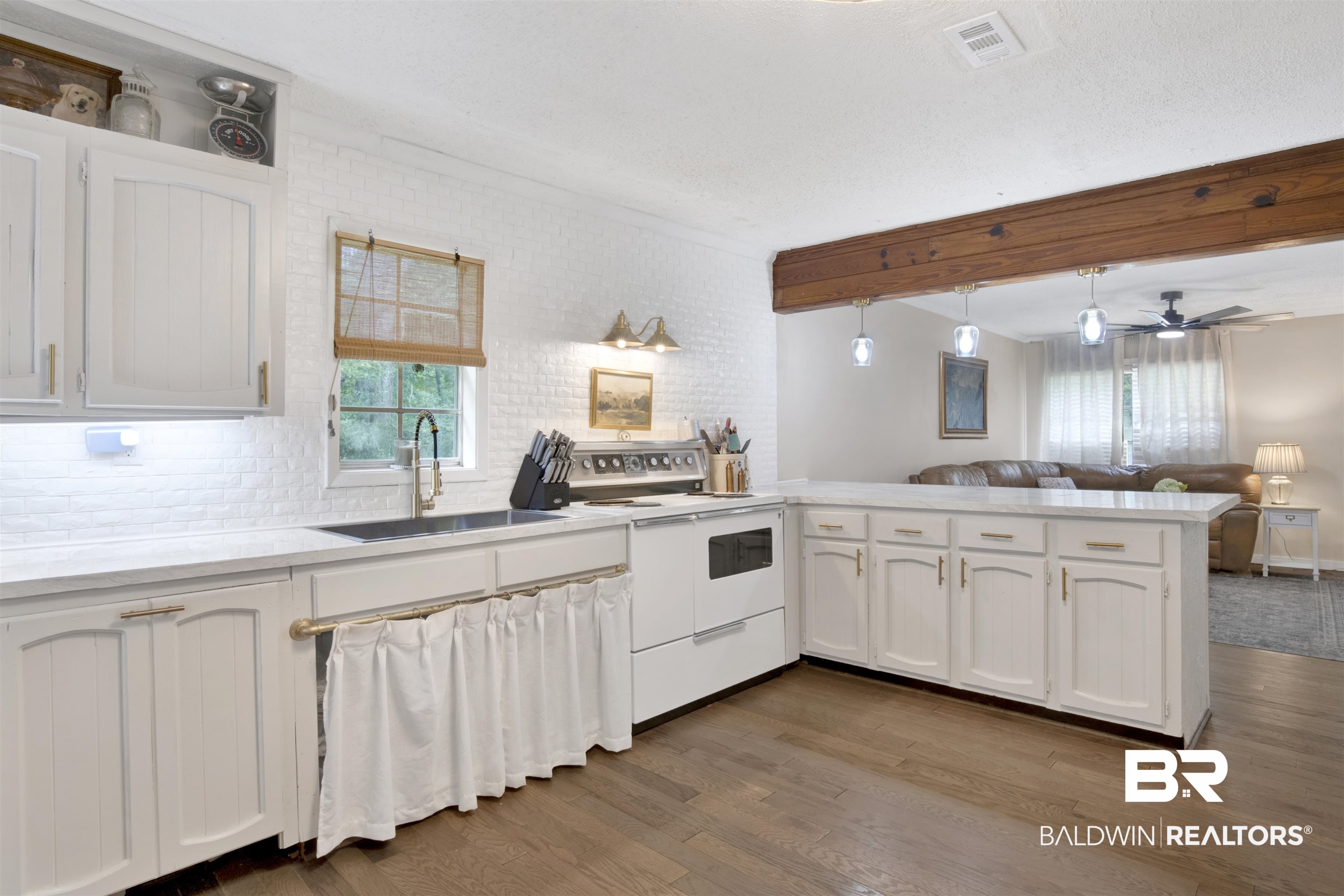 4265 Greaves Road Eight Mile, AL 36613 - Photo 34 of 34 Kitchen with electric stove, a peninsula, wood finished floors, open floor plan, and white cabinetry