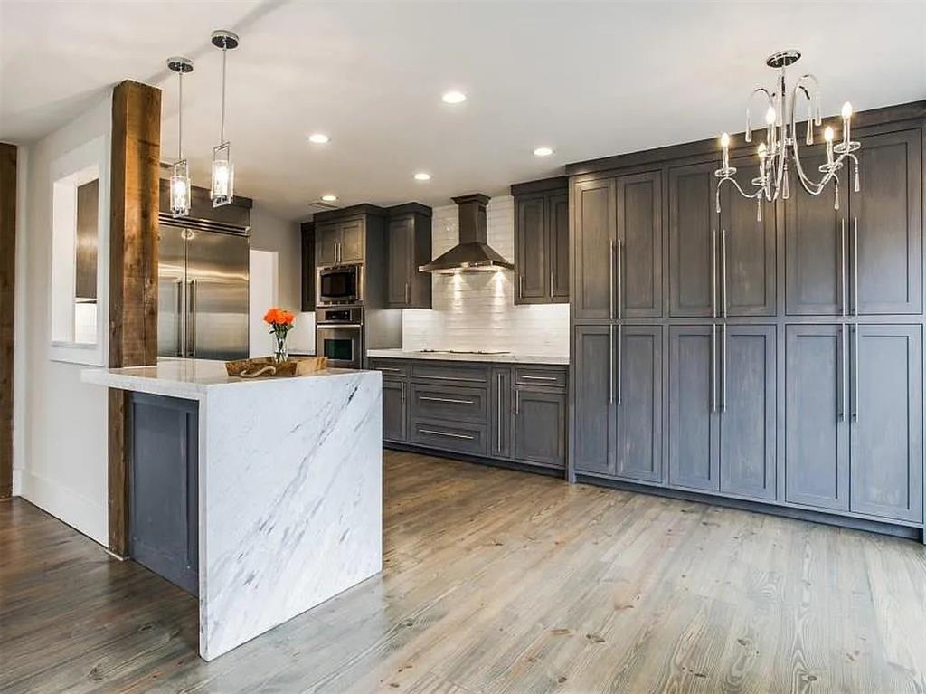 4310 Forest Bend Road Dallas, TX 75244 - Photo 12 of 34 a kitchen with kitchen island granite countertop wooden floors and wide window