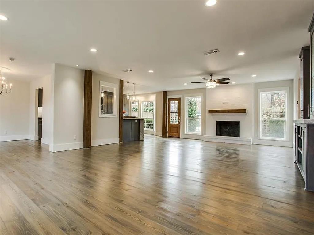4310 Forest Bend Road Dallas, TX 75244 - Photo 6 of 34 an empty room with wooden floor and a kitchen