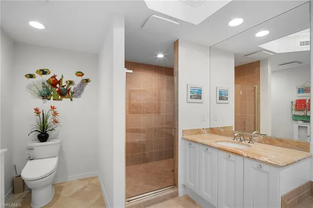a bathroom with a granite countertop sink a toilet and a shower