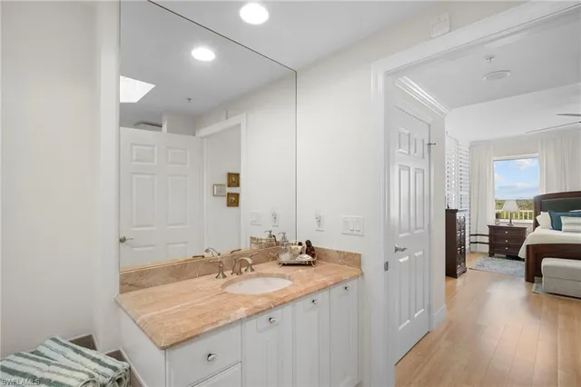 a en suite bathroom with a granite countertop sink and a mirror