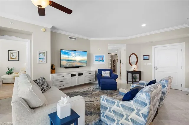 a living room with furniture a flat screen tv and white walls