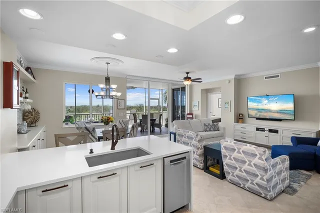 a kitchen with stainless steel appliances kitchen island a sink and a refrigerator