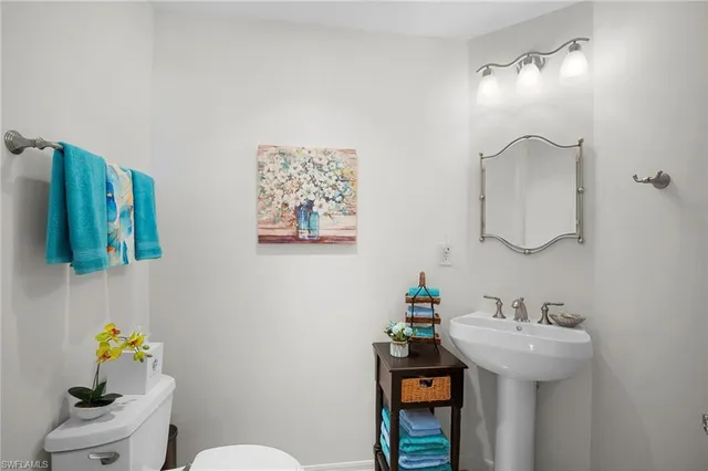 a bathroom with a sink mirror and toilet