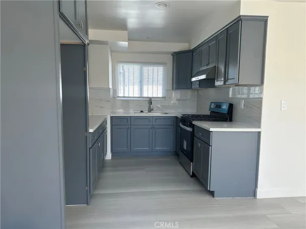 a kitchen with a sink cabinets and a window