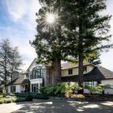a front view of a house with yard and trees
