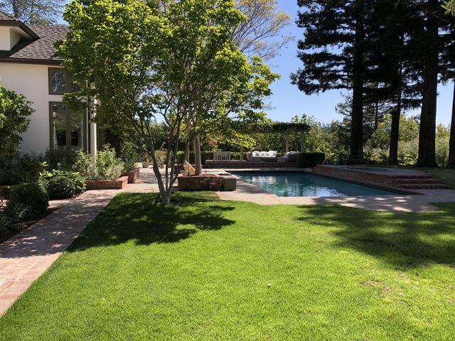 a view of a backyard with sitting area and garden