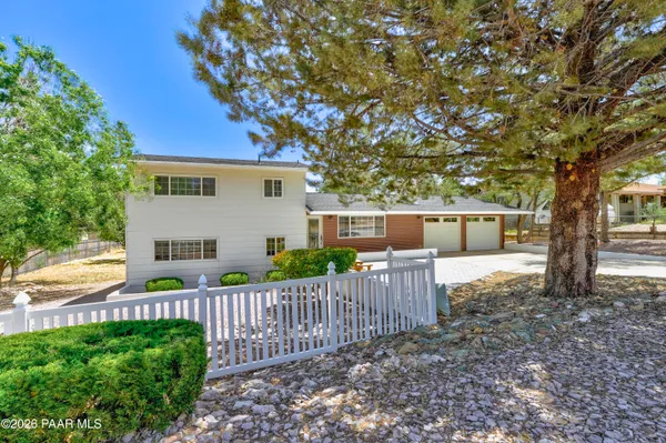 a view of a house with wooden fence next to a road