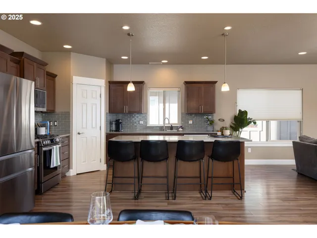 a living room with kitchen island granite countertop furniture wooden floor and a view of kitchen