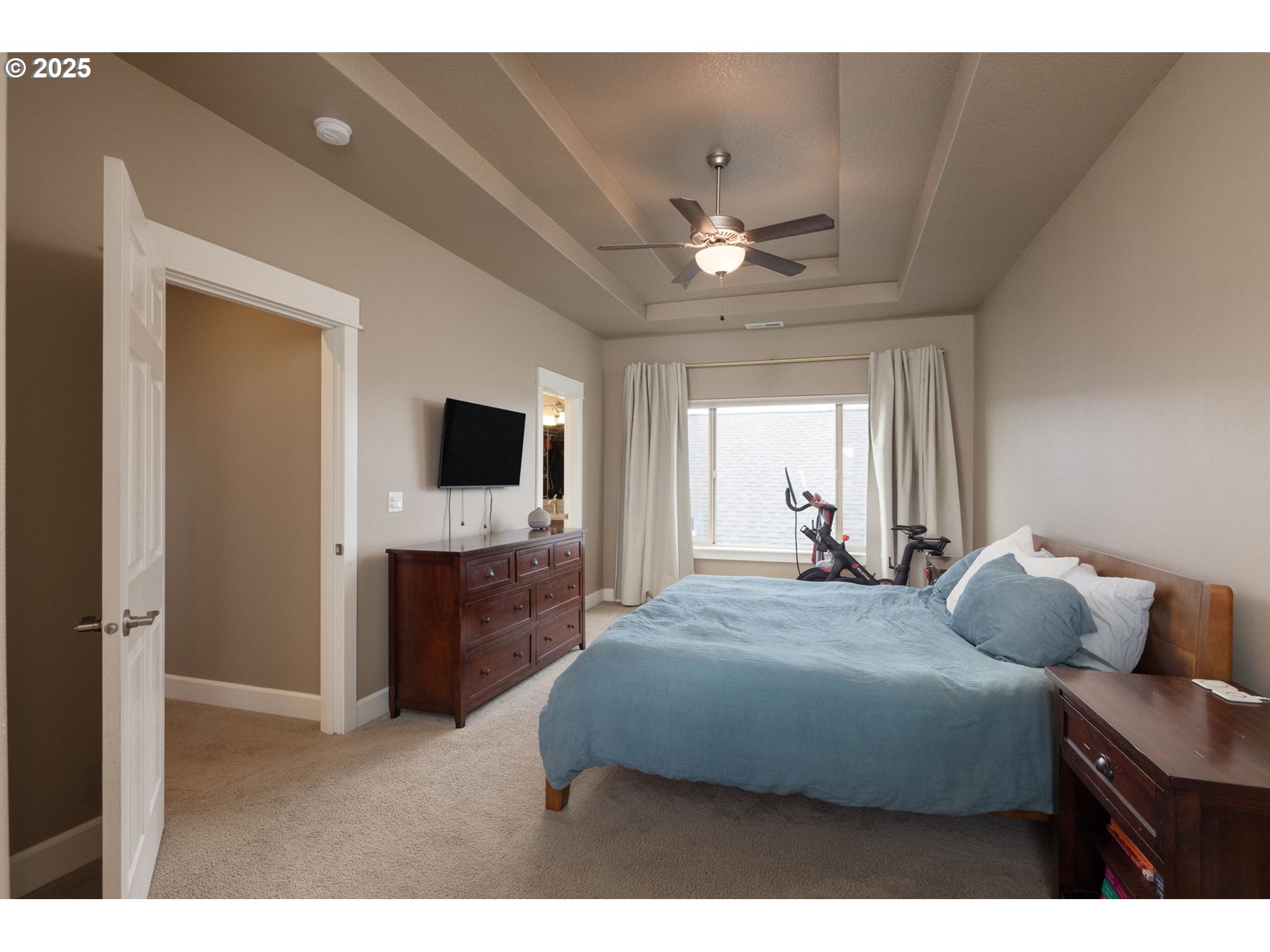 62905 Daniel Road Bend, OR 97701 - Photo 10 of 28 a bedroom with a bed and a flat screen tv