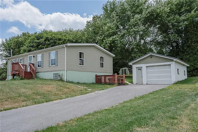 a view of a house with a yard and large tree