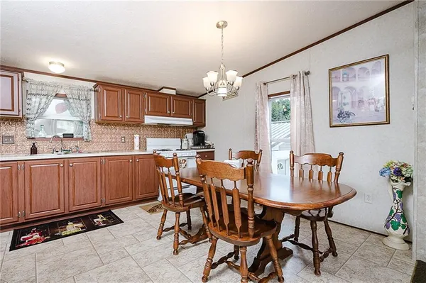 a kitchen with a dining table chairs and white cabinets