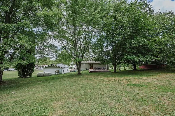 a front view of a house with a garden and trees