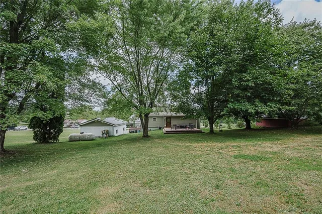 a front view of a house with a garden and trees