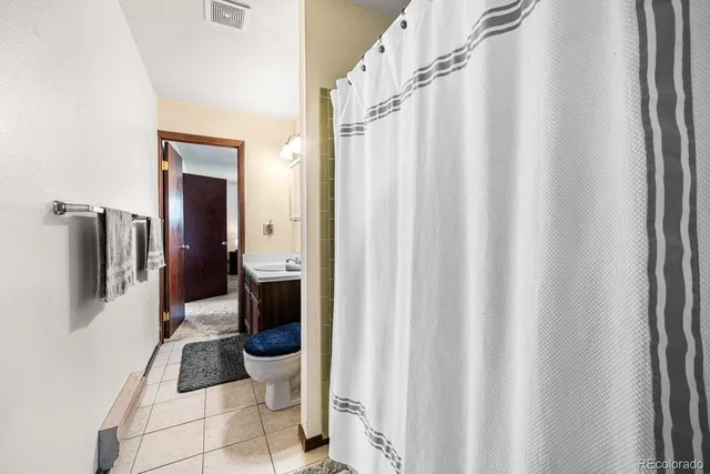 a bathroom with a toilet and a shower curtain