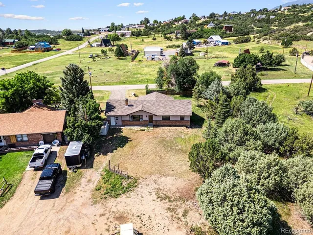 an aerial view of residential houses with outdoor space and trees