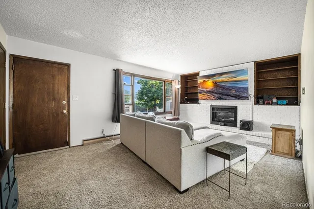 a living room with furniture a fireplace and a flat screen tv