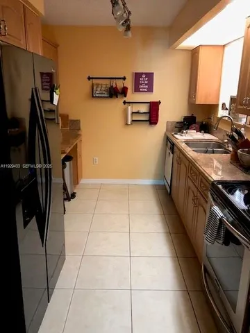 a kitchen with stainless steel appliances a sink a stove top oven a counter space and cabinets