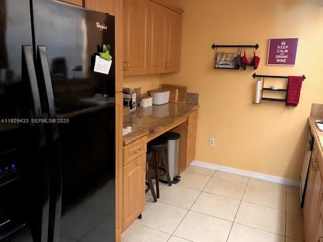 a view of kitchen cabinetry and refrigerator