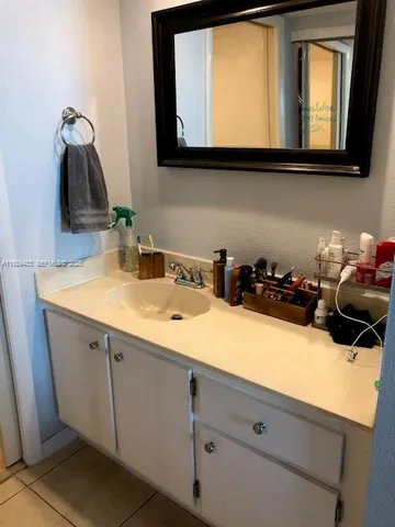 a bathroom with a sink a mirror and cabinets