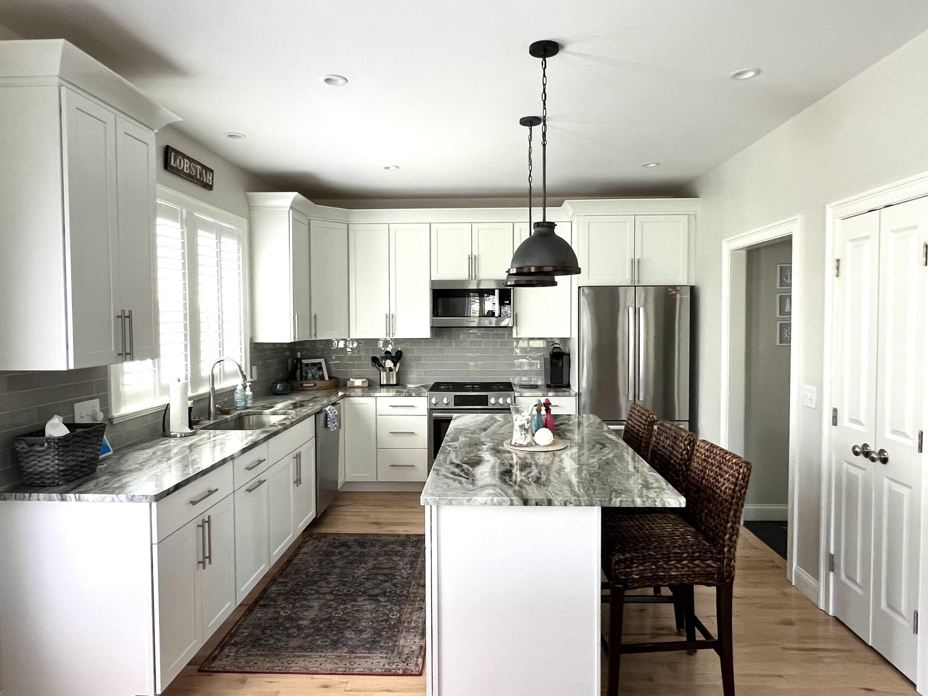 601 Ma Route, Unit 27 Dennis, MA 02638 - Photo 12 of 34 a kitchen with stainless steel appliances kitchen island granite countertop a sink refrigerator and cabinets