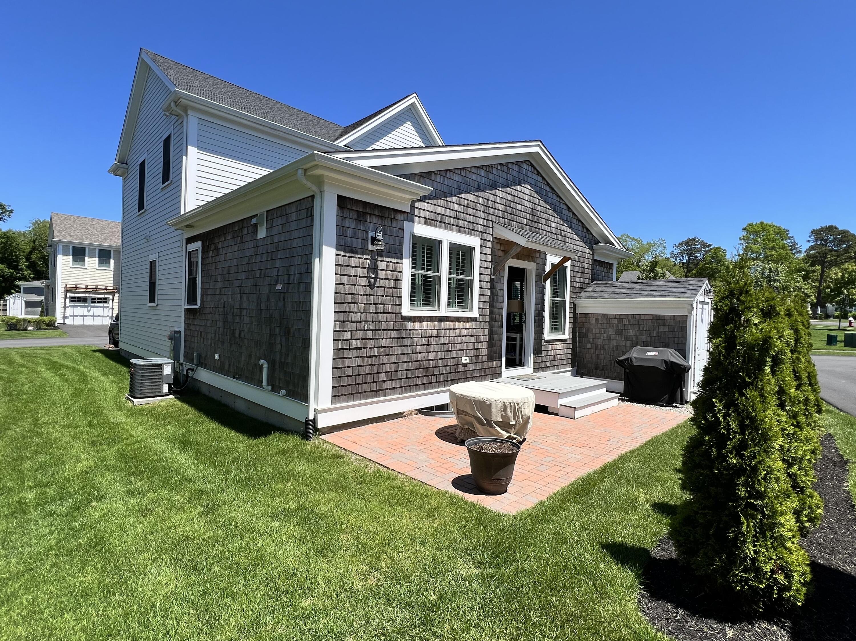 601 Ma Route, Unit 27 Dennis, MA 02638 - Photo 4 of 34 a view of a house with a yard fire pit and a patio
