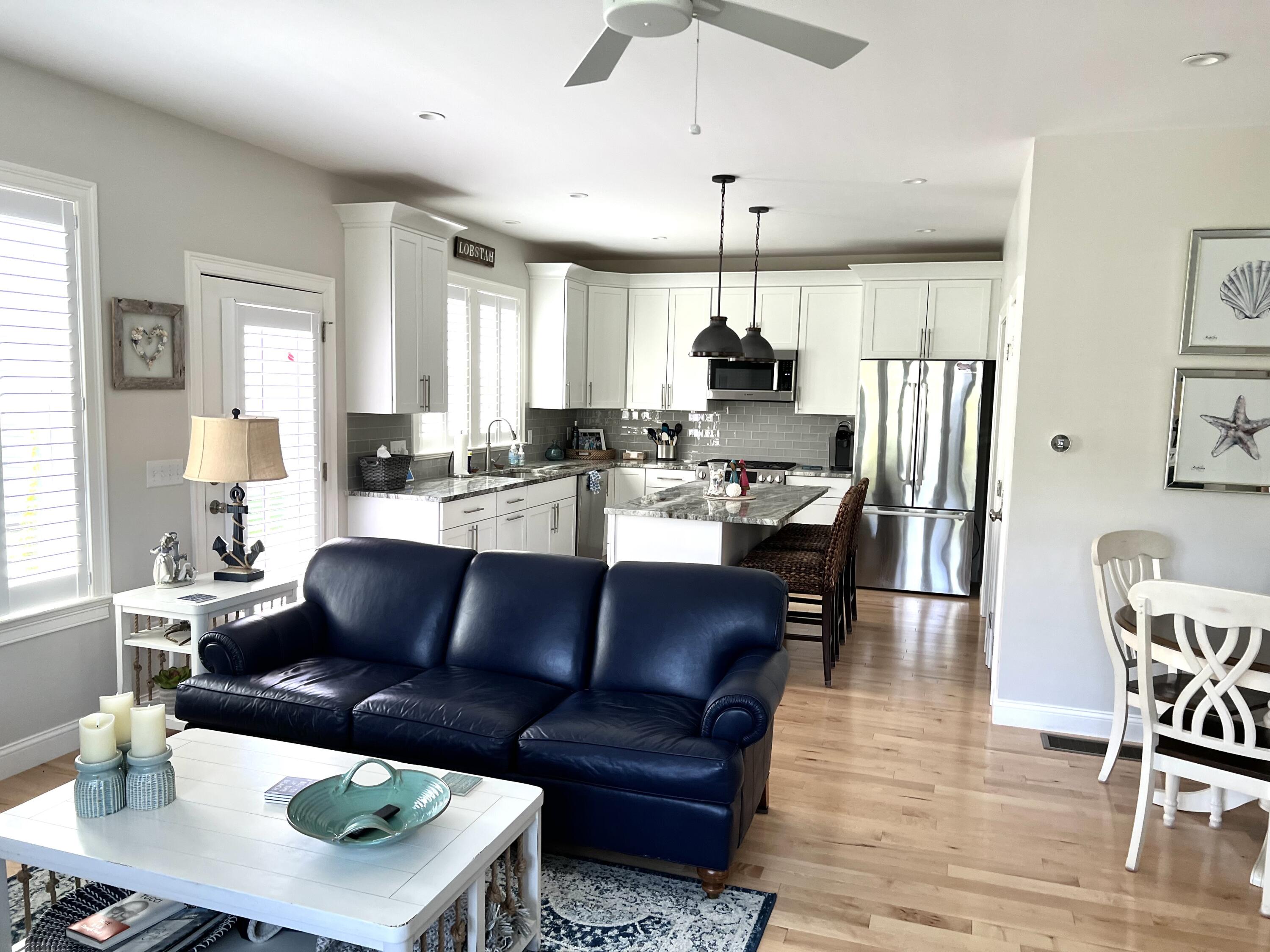 601 Ma Route, Unit 27 Dennis, MA 02638 - Photo 9 of 34 a living room with stainless steel appliances kitchen island granite countertop furniture and a wooden floor