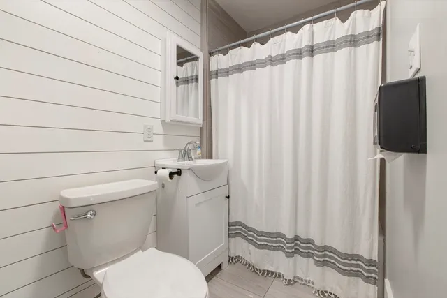 a white toilet sitting next to a shower curtain