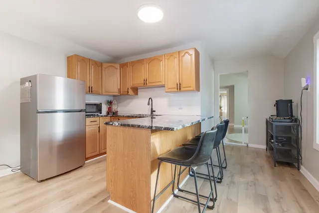 a kitchen with stainless steel appliances granite countertop a refrigerator a stove a sink dishwasher and a refrigerator with wooden floor