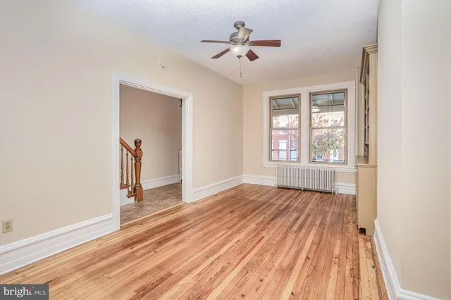 a view of a room with wooden floor chandelier and a window