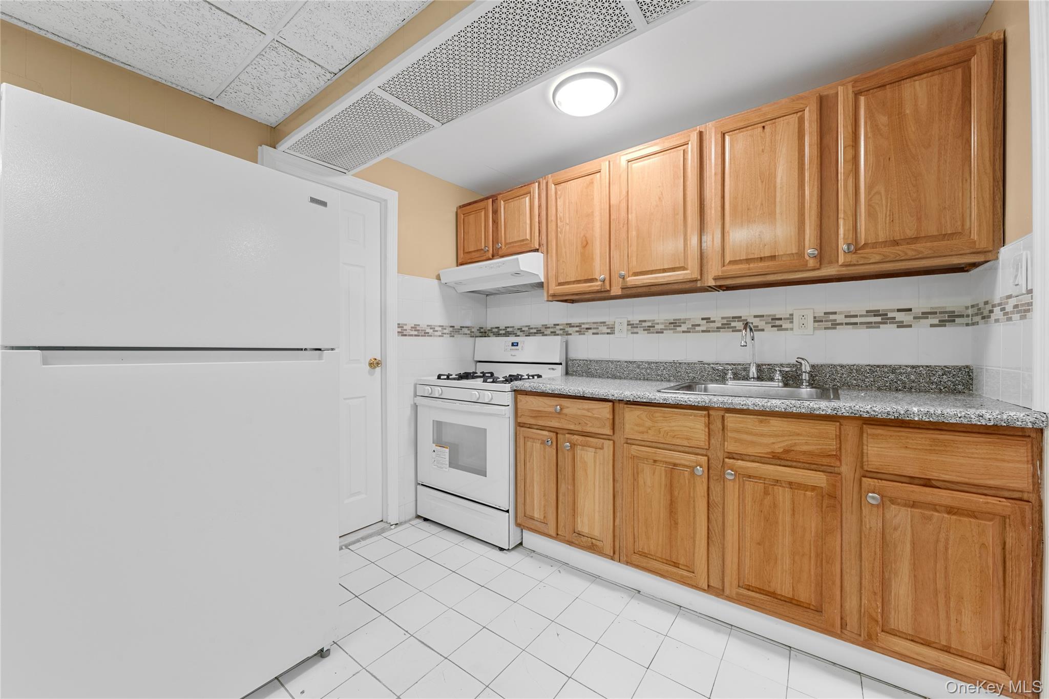 1331 Remsen Avenue Brooklyn, NY 11236 - Photo 11 of 30 a kitchen with granite countertop white cabinets and white appliances
