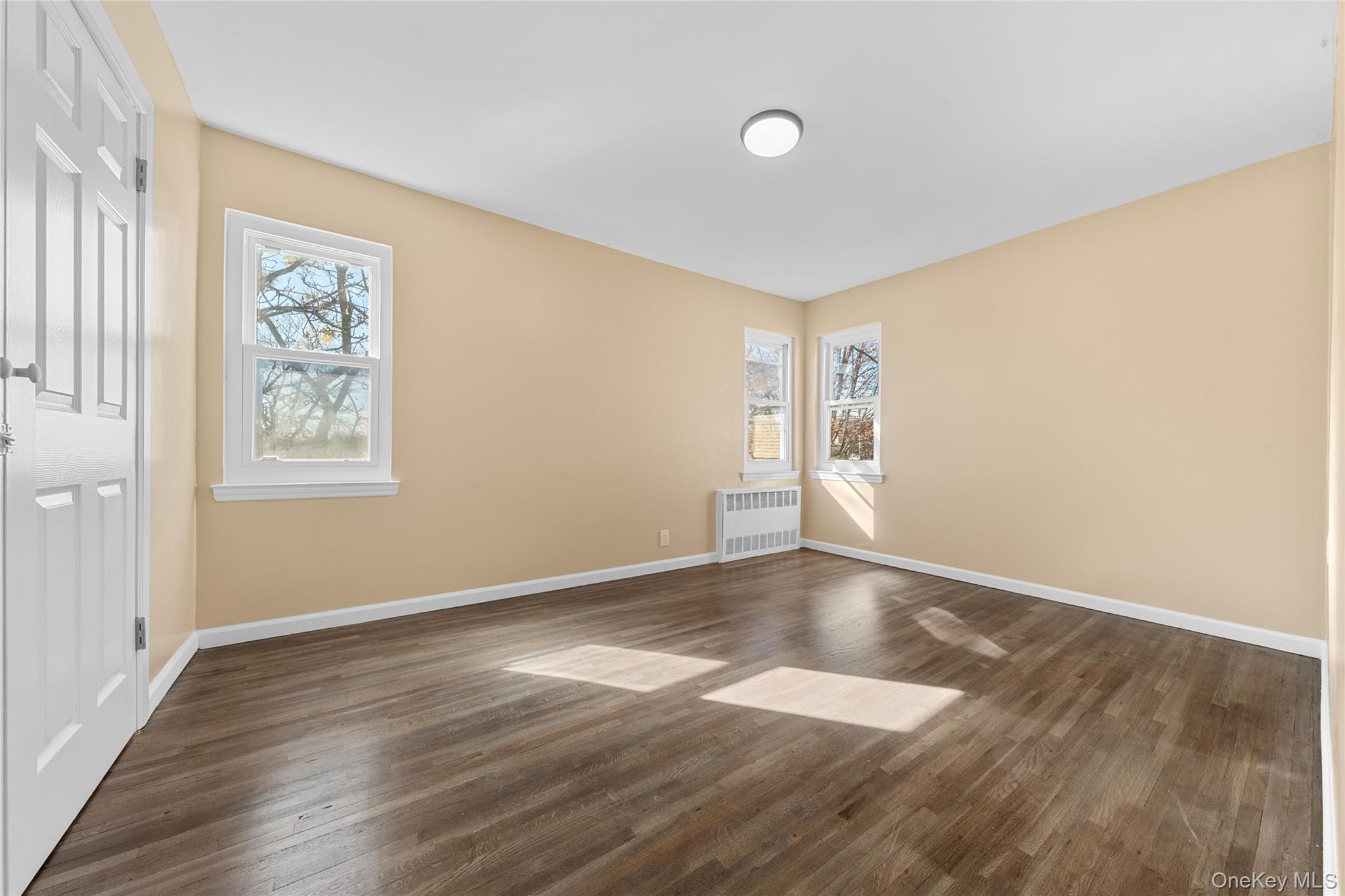 1331 Remsen Avenue Brooklyn, NY 11236 - Photo 16 of 30 an empty room with wooden floor and windows