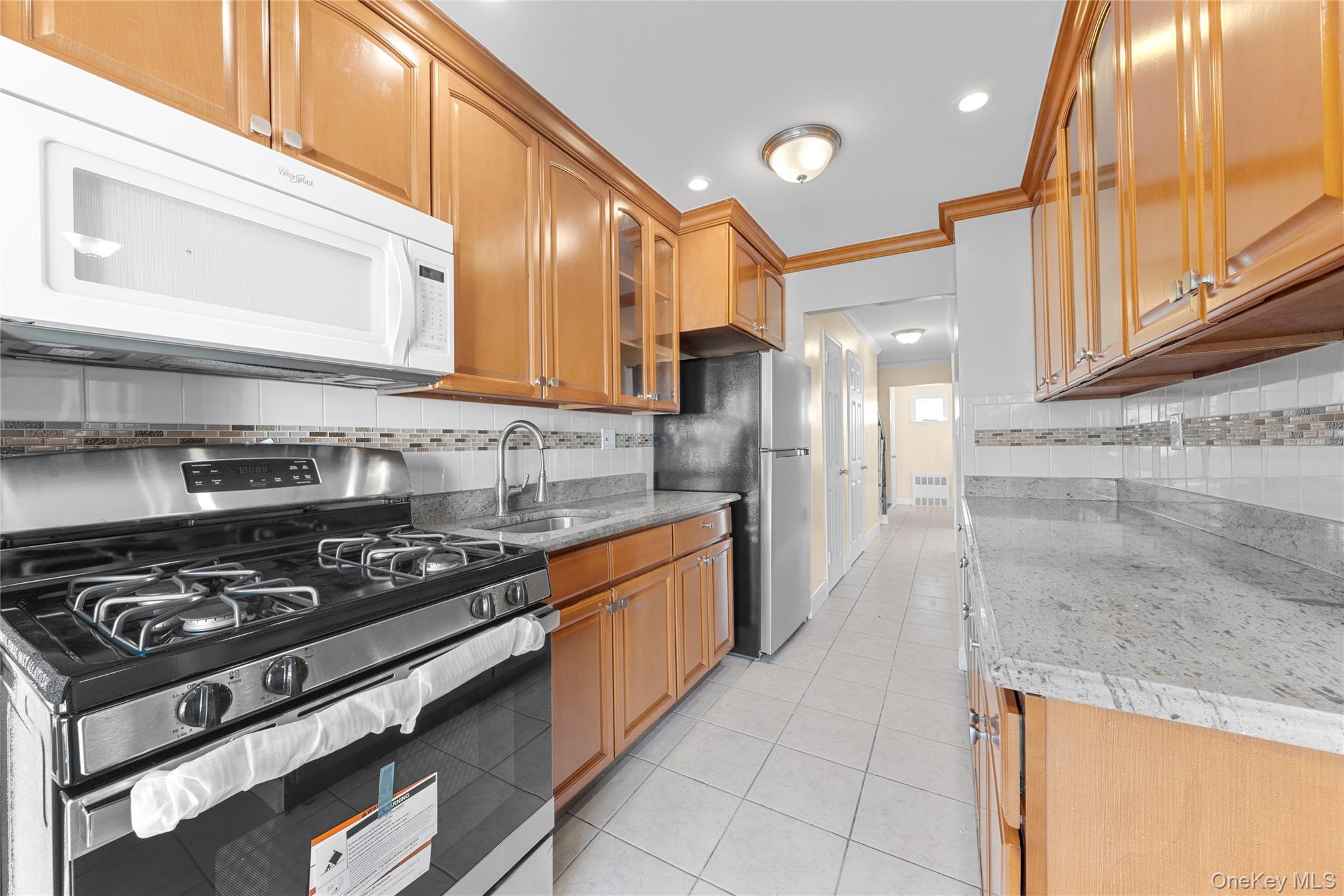 1331 Remsen Avenue Brooklyn, NY 11236 - Photo 17 of 30 a kitchen with stainless steel appliances granite countertop a stove a sink and a refrigerator