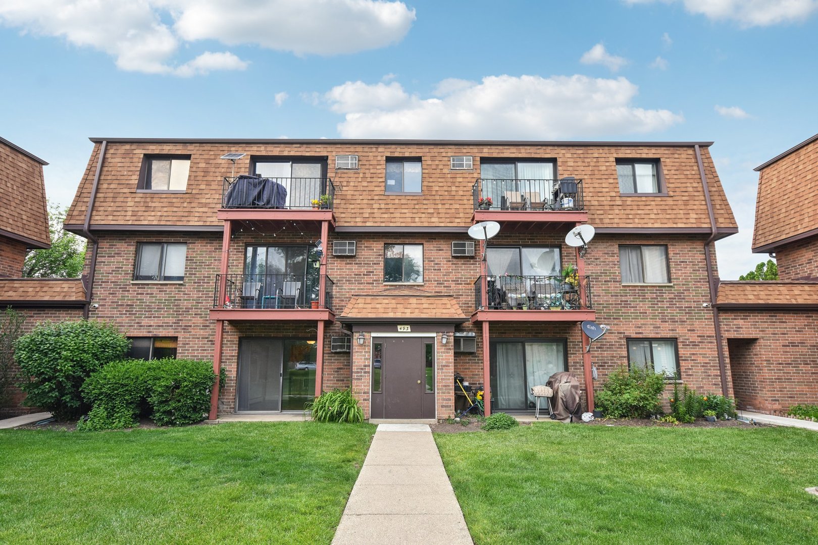 a front view of a brick house with a yard