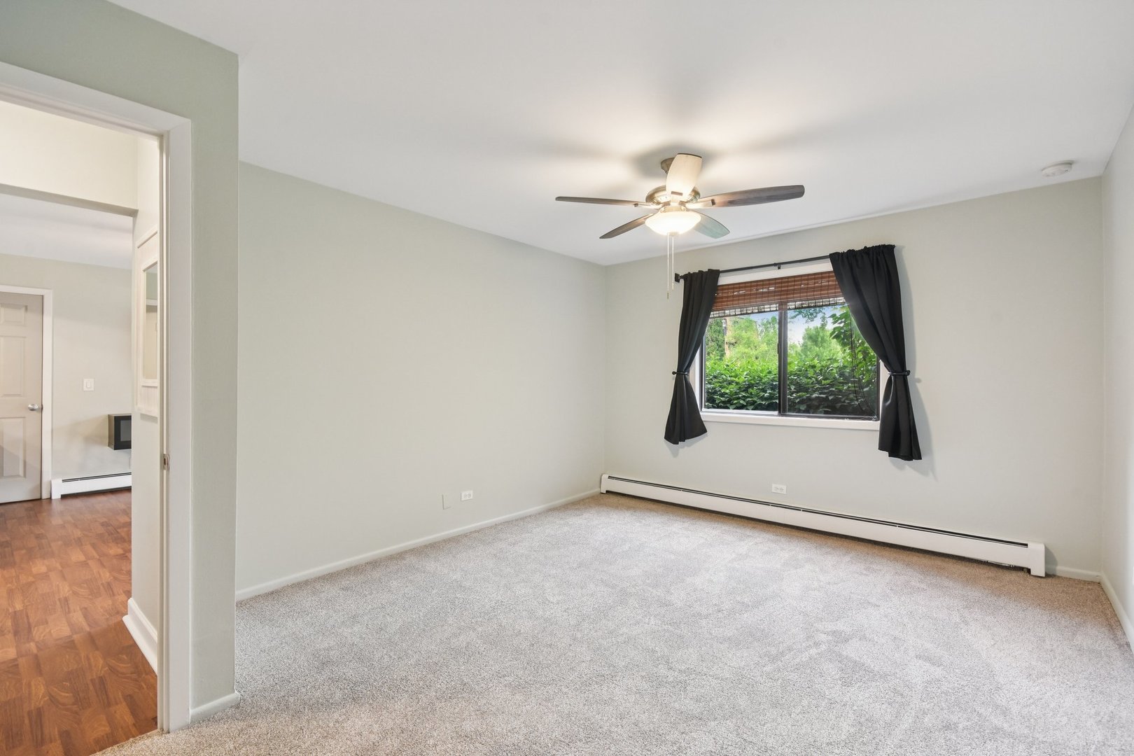 493 McHenry Road, Unit 1B Wheeling, IL 60090 - Photo 16 of 30 an empty room with chandelier fan and windows