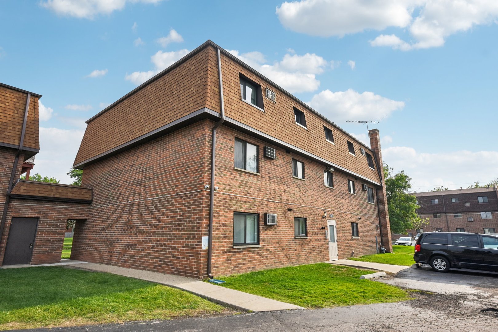 493 McHenry Road, Unit 1B Wheeling, IL 60090 - Photo 21 of 30 a car parked in front of a brick house