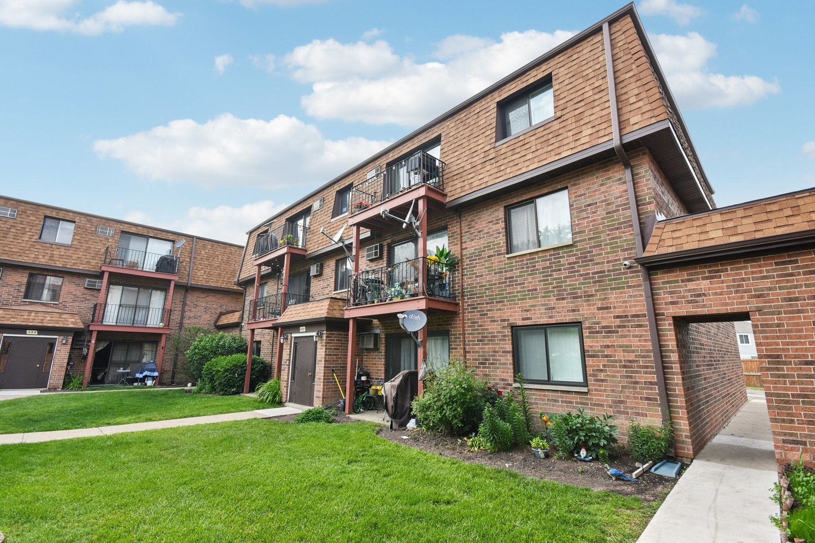 493 McHenry Road, Unit 1B Wheeling, IL 60090 - Photo 23 of 30 a view of a brick building next to a yard