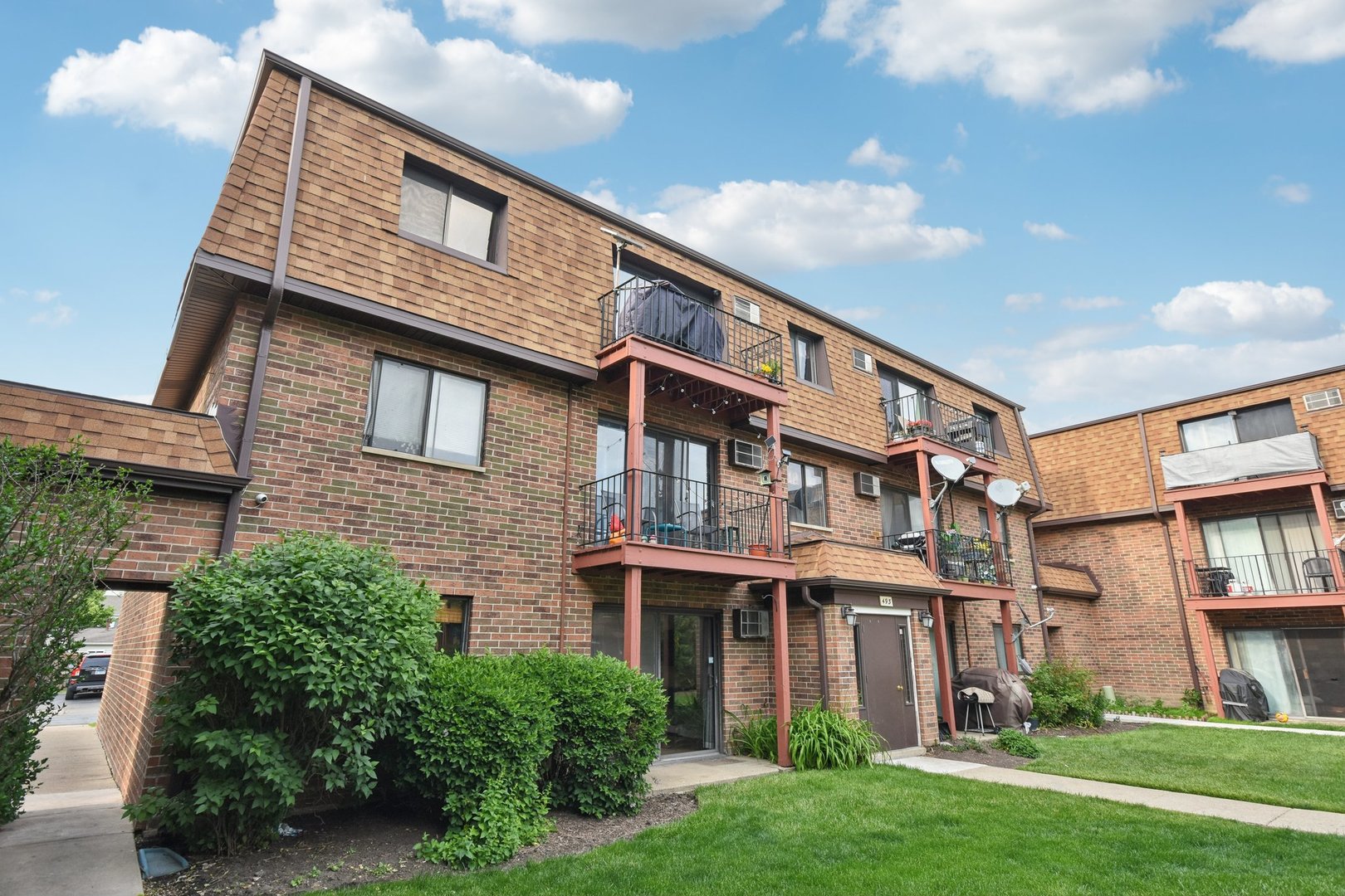 493 McHenry Road, Unit 1B Wheeling, IL 60090 - Photo 24 of 30 a front view of a house with garden