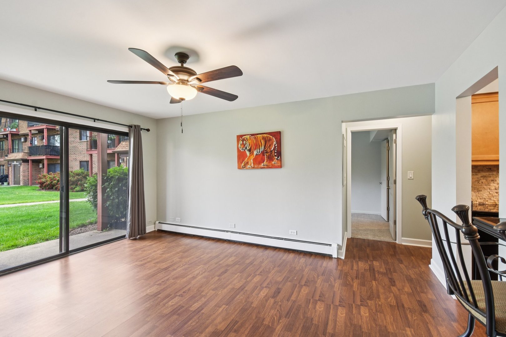 493 McHenry Road, Unit 1B Wheeling, IL 60090 - Photo 7 of 30 a view of a livingroom with hardwood floor and a ceiling fan