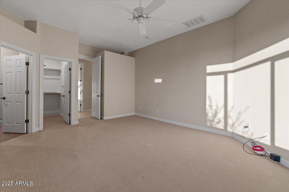 8540 East McDowell Road, Unit 119 Mesa, AZ 85207 - Photo 43 of 94 an empty room with chandelier fan and windows