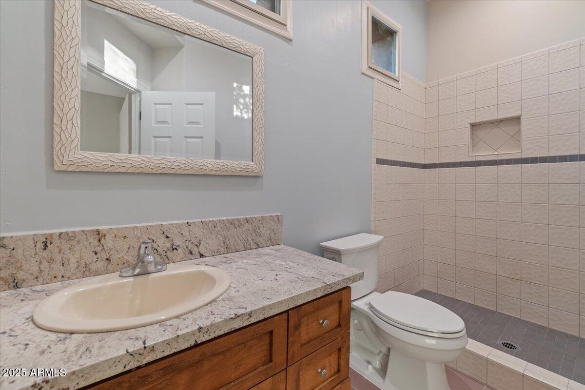 8540 East McDowell Road, Unit 119 Mesa, AZ 85207 - Photo 44 of 94 a bathroom with a granite countertop sink and a toilet