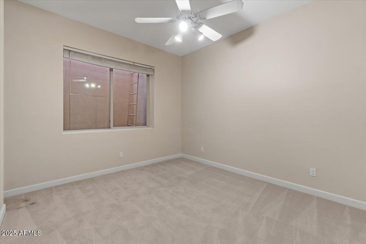 8540 East McDowell Road, Unit 119 Mesa, AZ 85207 - Photo 62 of 94 an empty room with a chandelier fan and windows