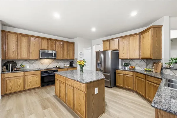 a kitchen with stainless steel appliances granite countertop refrigerator sink and cabinets