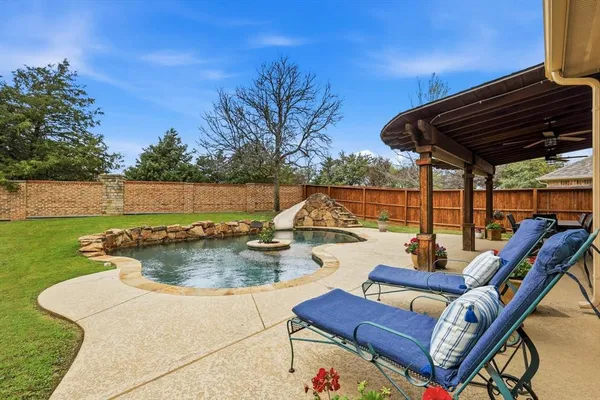 a view of a patio with a table chairs and a grill