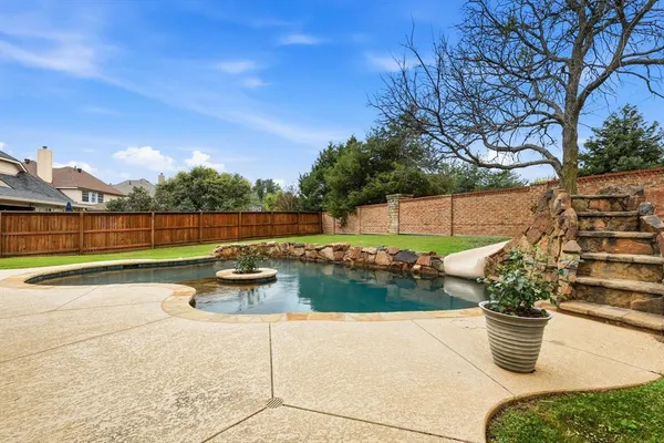a view of a swimming pool with chairs and fire pit
