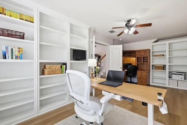 a living room with furniture a flat screen tv and a book shelf